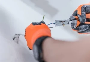Electrician using pliers to install electrical wiring, showcasing professional electrical services for residential and commercial needs in Miami.